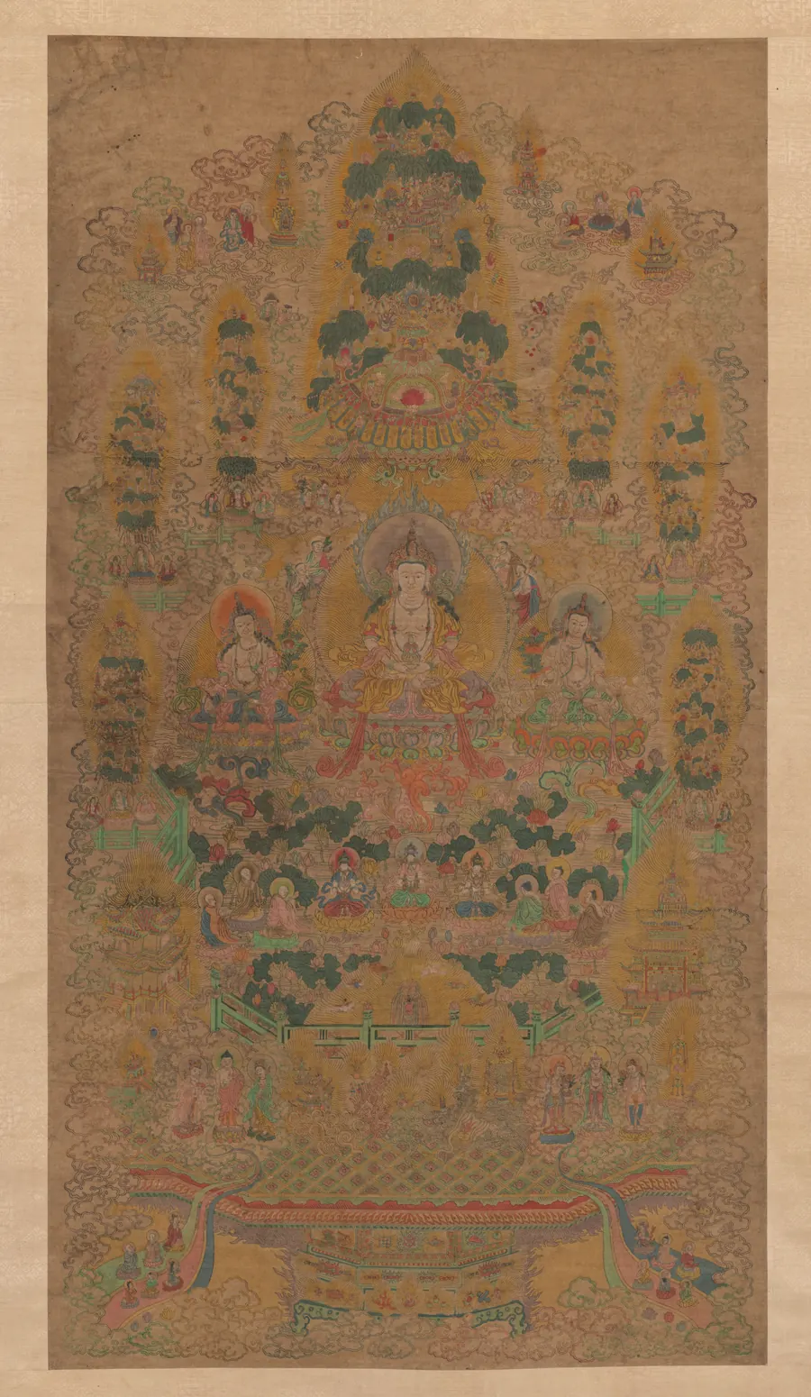 Ortadaki oturan bir figürün çevresinde katman katman dizilmiş yaldızlı ve renkli desenlerden oluşan Tibet mandalası.