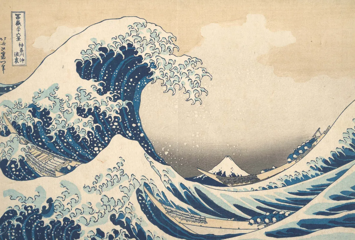 Kayıkların üzerine kıvrılan dev mavi dalga; uzakta küçük bir Fuji Dağı. Japon ahşap baskısı.